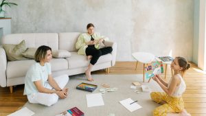 A family enjoying creative activities together in a bright living room setting.