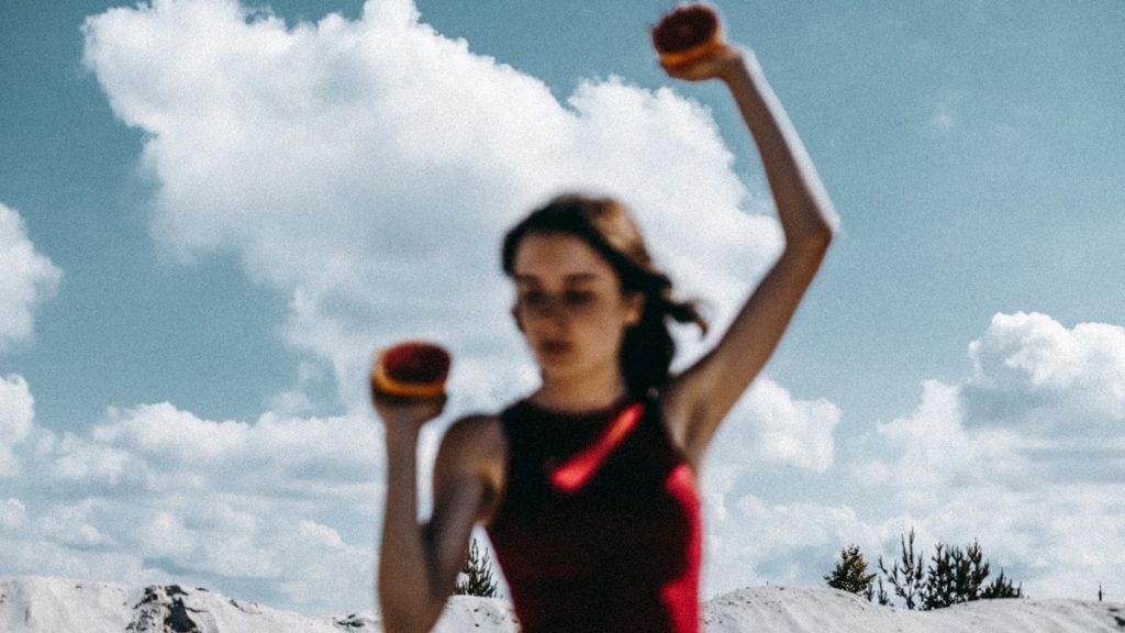 a woman holding two oranges in her hands